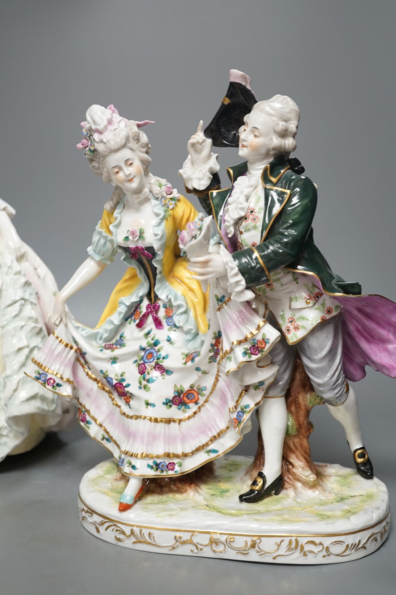 An Italian porcelain group of a dancing couple, 31cm, and an Italian maiolica figure of a lady